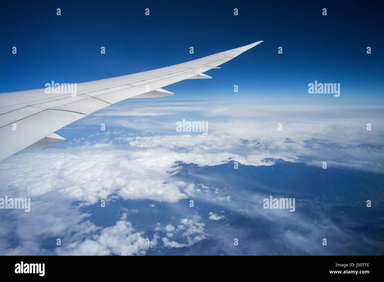 wing of an airplane flying above the clouds Stock Photo - Alamy