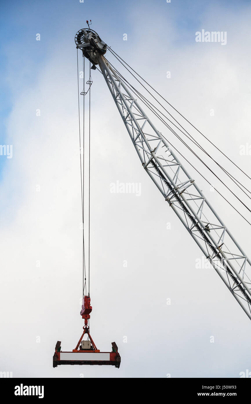 https://c8.alamy.com/comp/J50W93/steel-crane-boom-with-container-spreader-hanging-on-ropes-J50W93.jpg