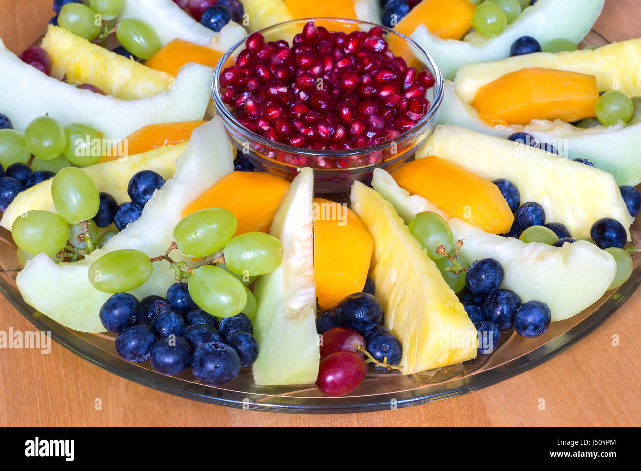 Glass scale on wooden floor filled with mixed fresh fruit Stock Photo