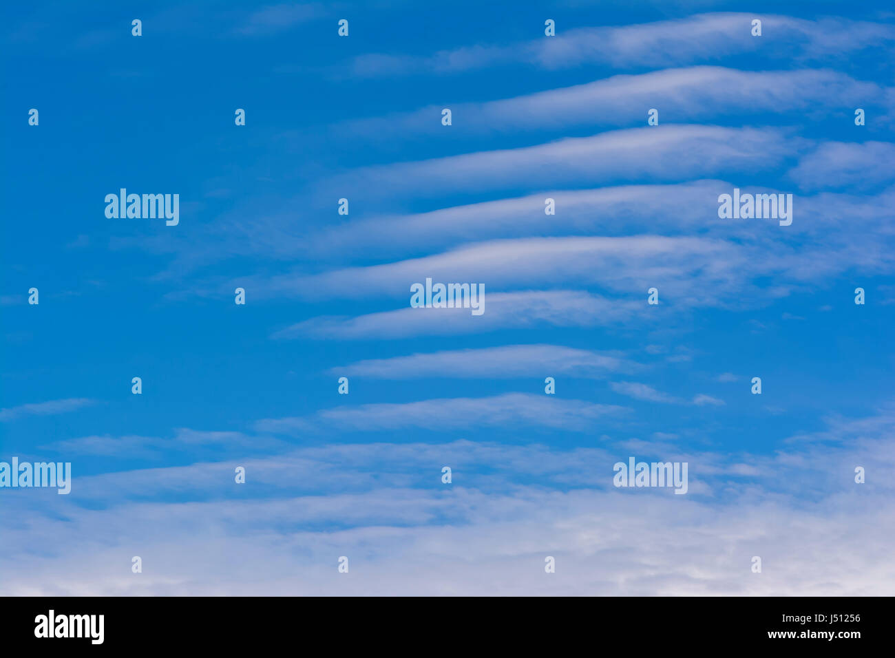 Cloudscape featuring wispy white cloud stripes on a vibrant blue sky. Background suitable Stock Photo