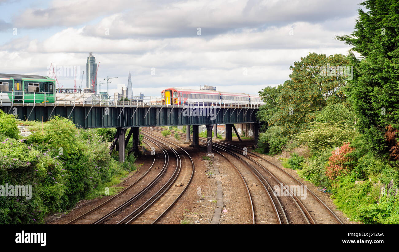 London, England, UK - June 14, 2014: A Southern commuter train and Gatwick Express passenger train cross a flyover at Clapham Junction in south west L Stock Photo