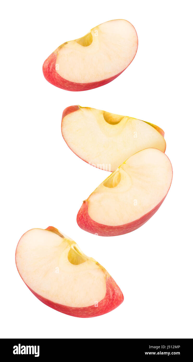 Isolated flying apple wedges. Four falling pieces of red apple fruit