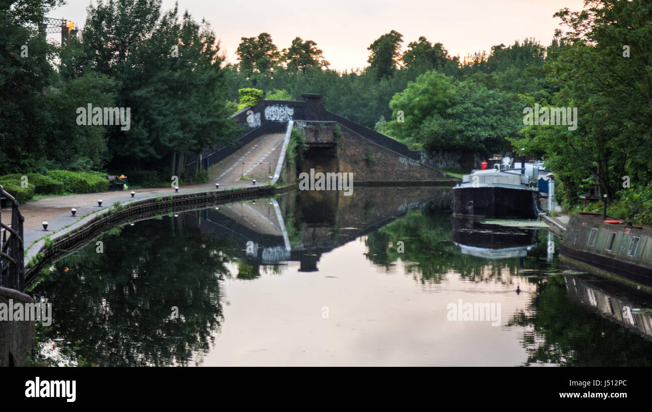 A bridge reflected in the waters of the Grand Union Canal at Ladbroke Grove in west London. Stock Photo