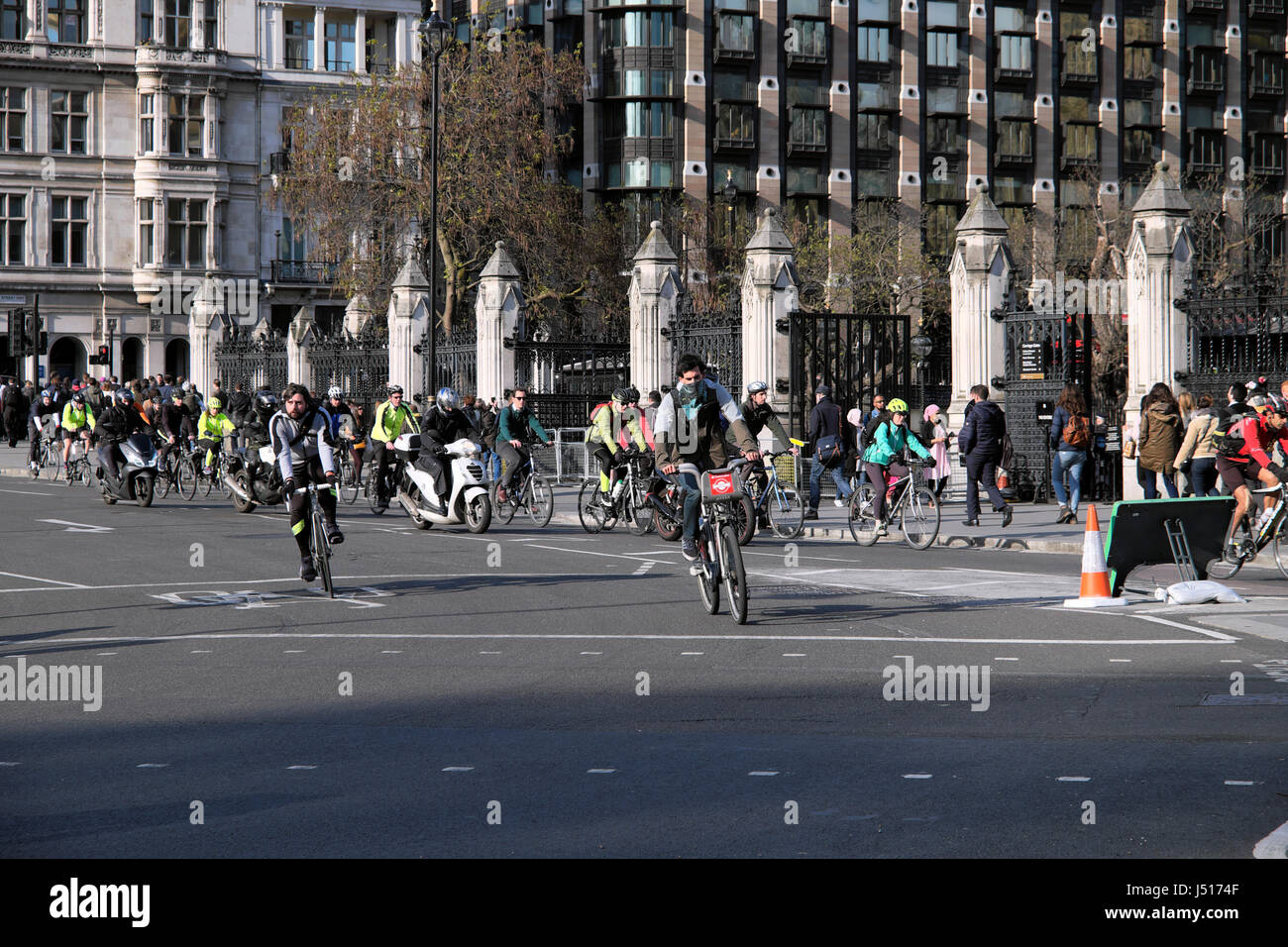 Commuters cyclists leaving work cycling near Parliament Square outside the Houses of Parliament in Westminster, London England UK  KATHY DEWITT Stock Photo