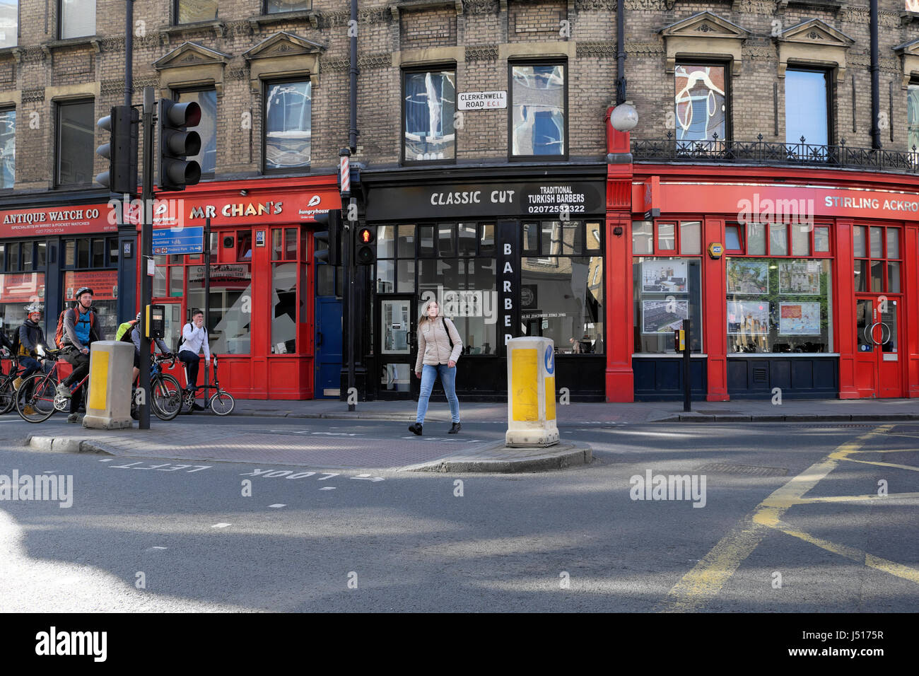 People cycling to work cycle past small shops on the corner of St John Street and Clerkenwell Road in London EC1 UK   KATHY DEWITT Stock Photo