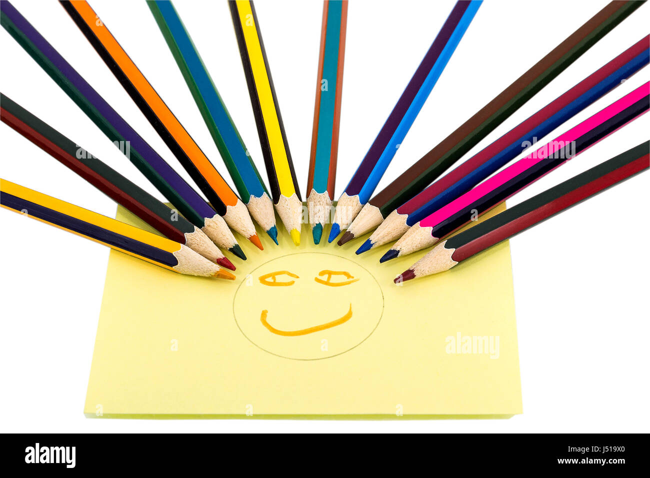 Smiley from colored pencils and yellow sticker with painted face, isolated on white background Stock Photo
