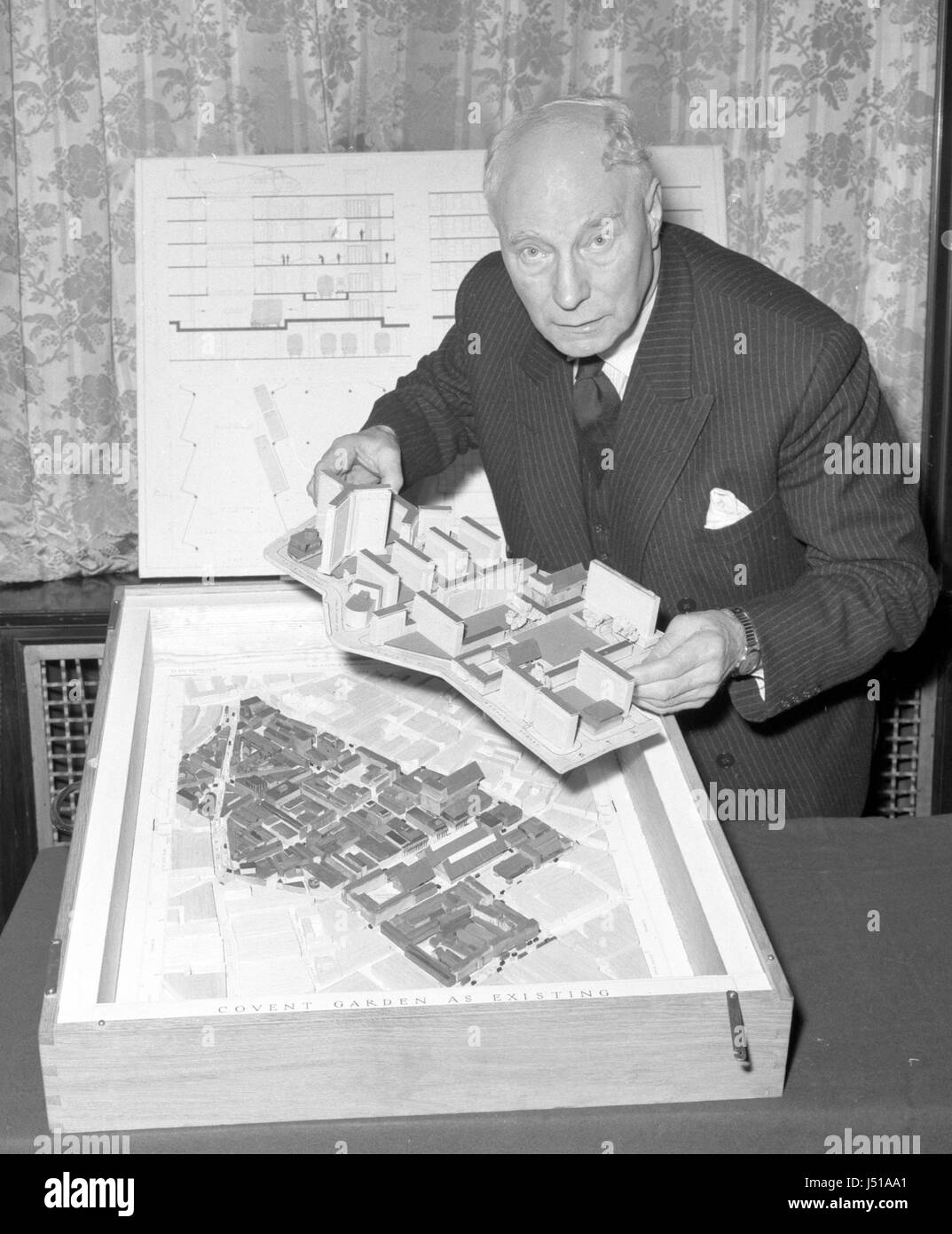 A £6m scheme to rebuild congestion prone Covent Garden over the railway sidings at King's Cross with a roof heliport, has been announced in London. The man behind the scheme is 69-year-old engineer Charles Glover - seen here holding a model of the proposed scheme above a plan of the present market. Stock Photo