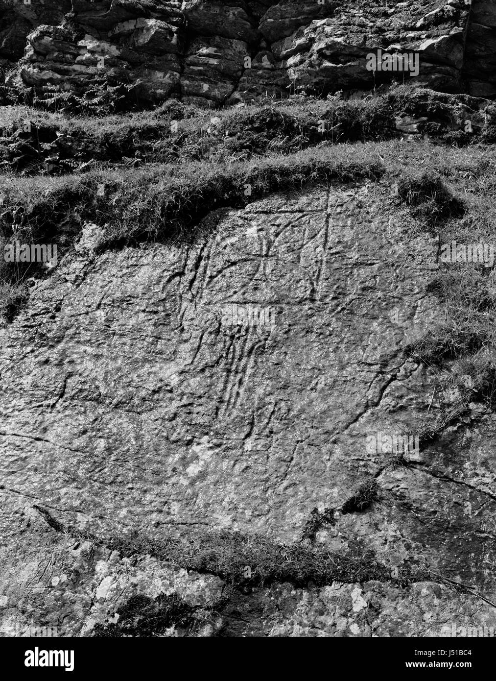 Pictish Christian symbol carved on rock face overlooking Churchton Bay, Isle of Raasay, off Skye, Scotland. Flabellum (ritual fan) & equal arm cross. Stock Photo