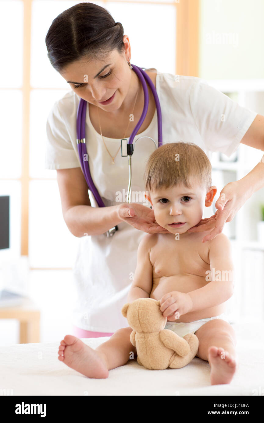 Doctor touching the throat of child patient in the office Stock Photo