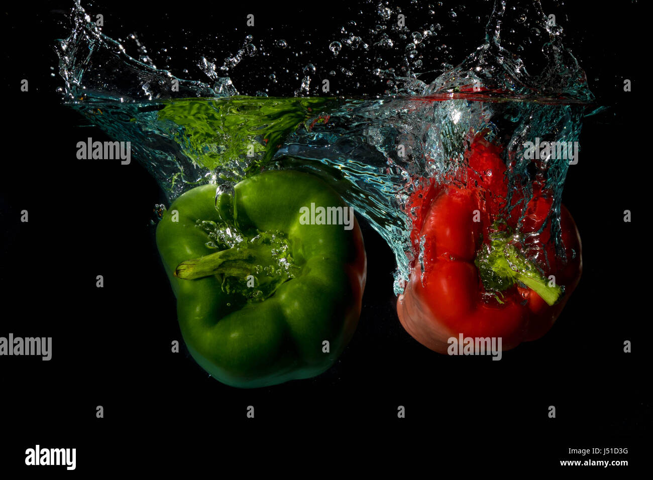 Green & Red Bell Sweet Peppers Droped Into Water Stock Photo
