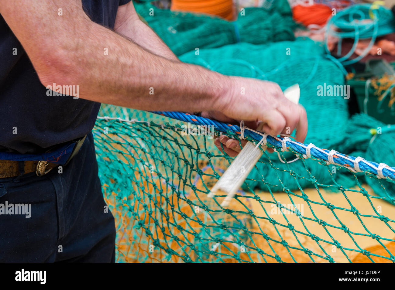 Fishing net maker demonstrates his craft in his shed in Ireland with copy space. Stock Photo