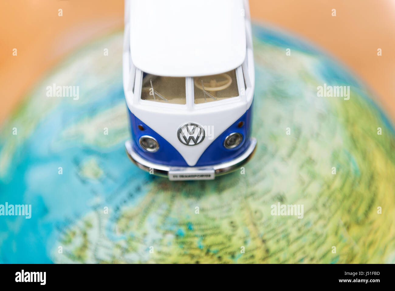 Concept of a world trip with globe and Volkswagen T1 Transporter van driving over the planet Stock Photo