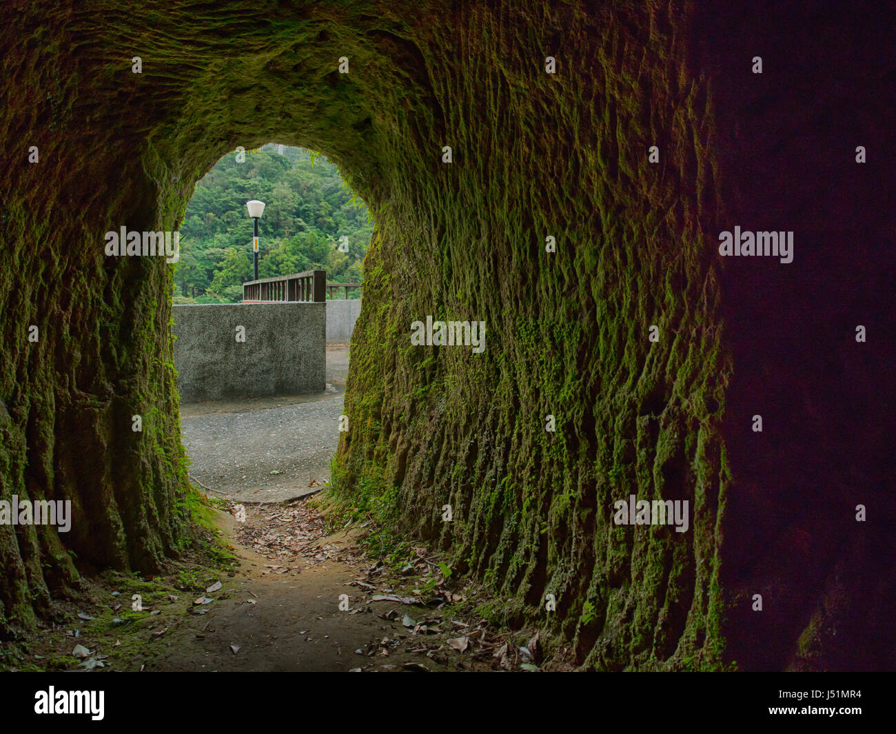 Cave rock covered with moss near a Taiwanese temple in the village of Pingxi. Pingxi is a small town in New Taipei Stock Photo