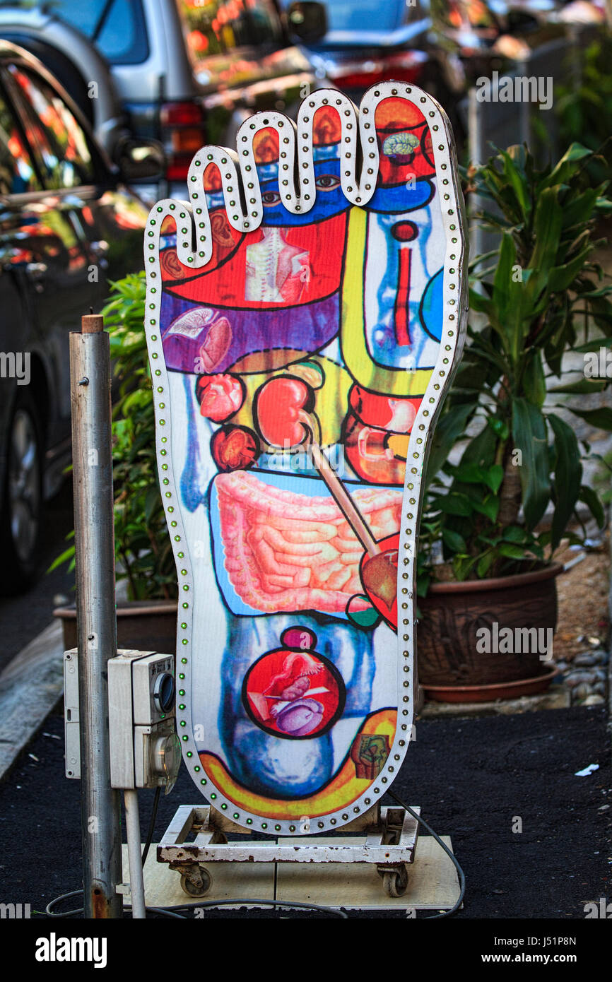 A giant foot advertises a reflexology and massage business in Kuala Lumpur, Malaysia, Southeast Asia. Stock Photo