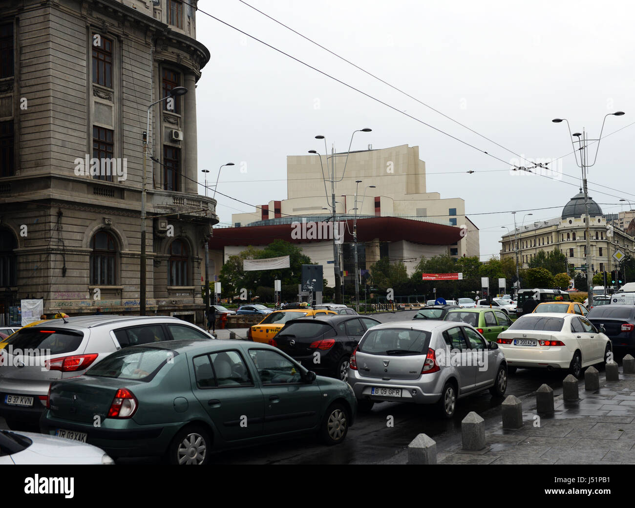 Traffic on Nicolae Bălcescu avenue next to the national theater and universitate circle in Bucharest city center. Stock Photo