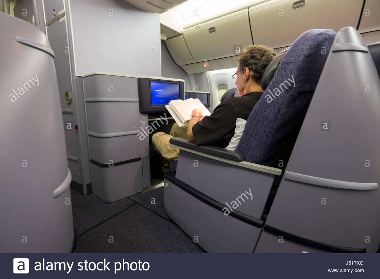 Man Reading Book Sitting In The First Class Cabin Of A United