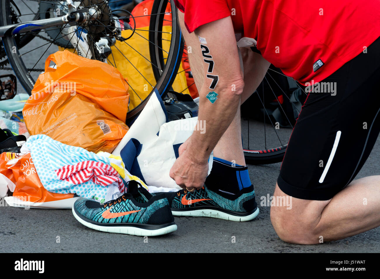 Male competitor putting on Nike running shoes, transition area, Stratford  Triathlon, UK Stock Photo - Alamy