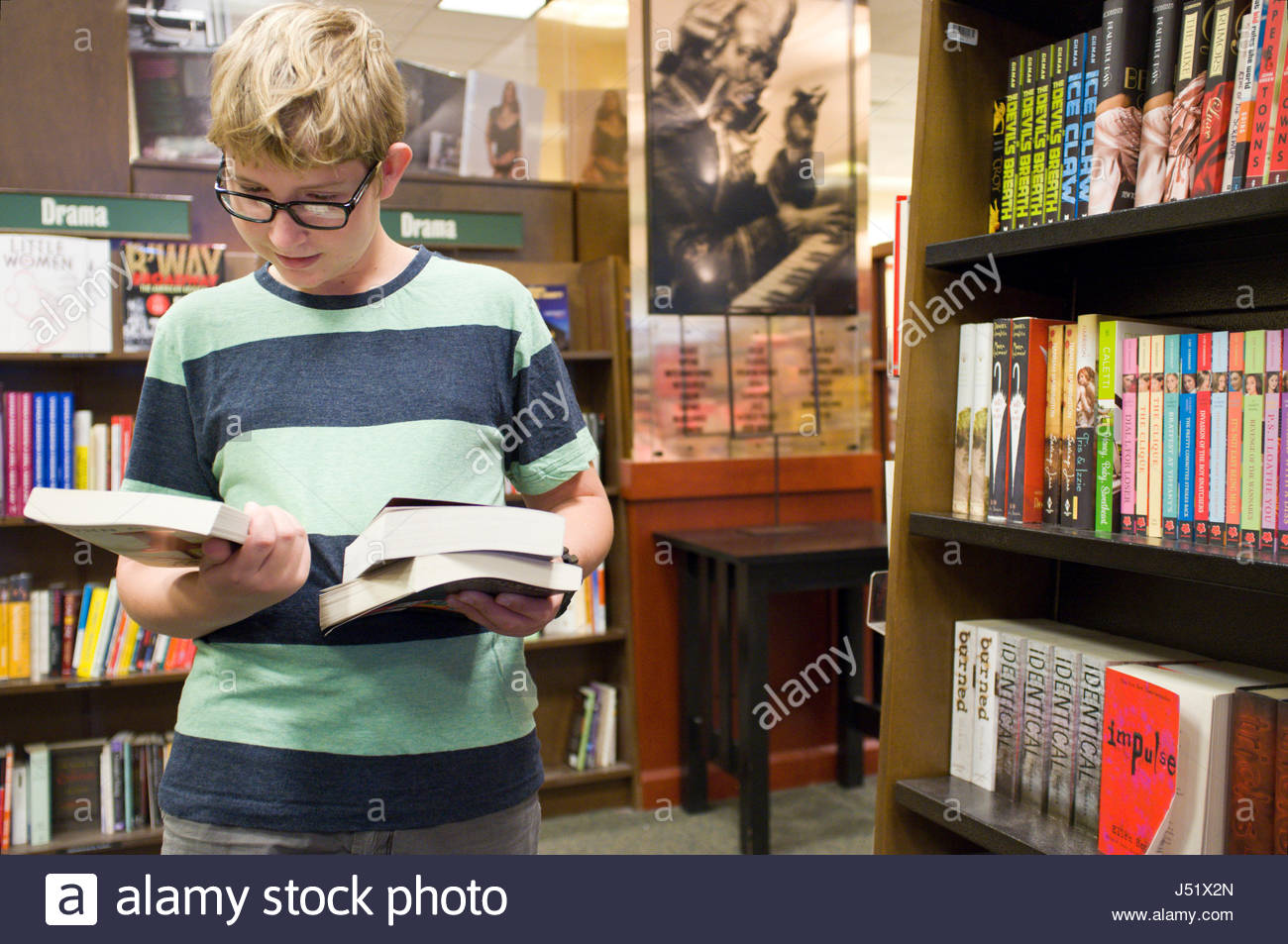 Teenage Caucasian Boy Looking For Books In The Young Adult Reader