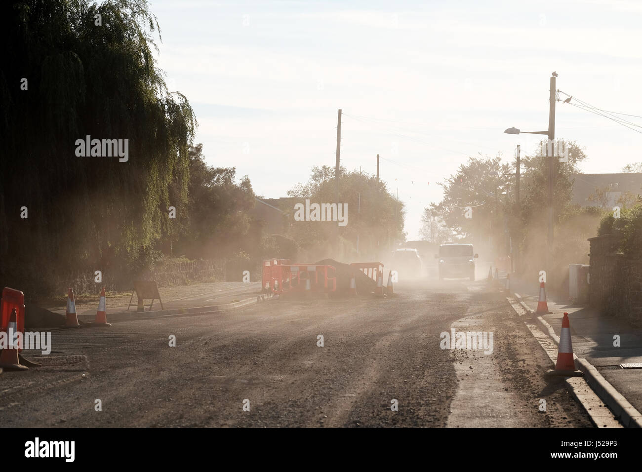 A very dusty road after the old surface had been removed to prepare for a new top coat of tarmacadam Stock Photo