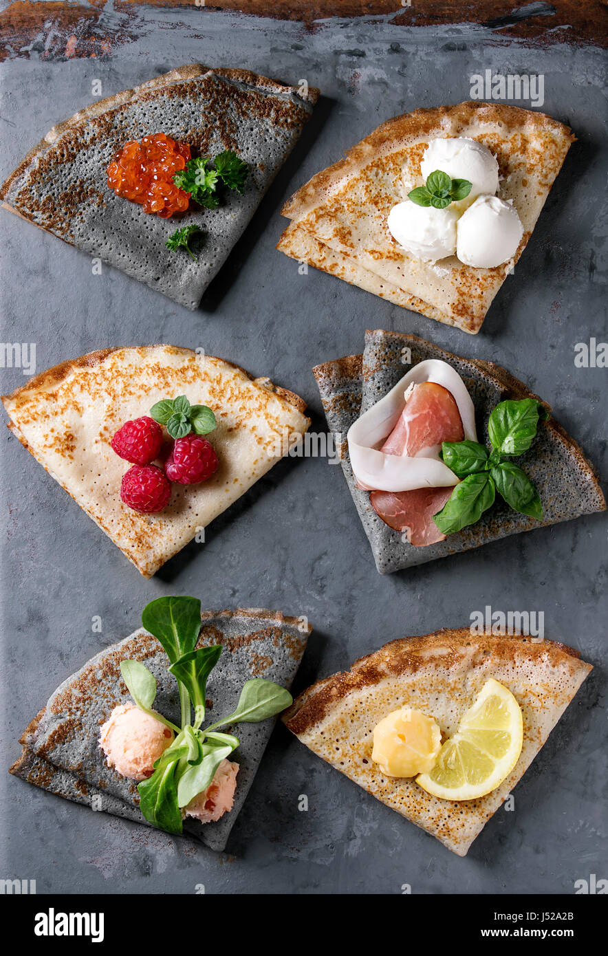 Variety of black and white crepe pancakes with different sweet and salt