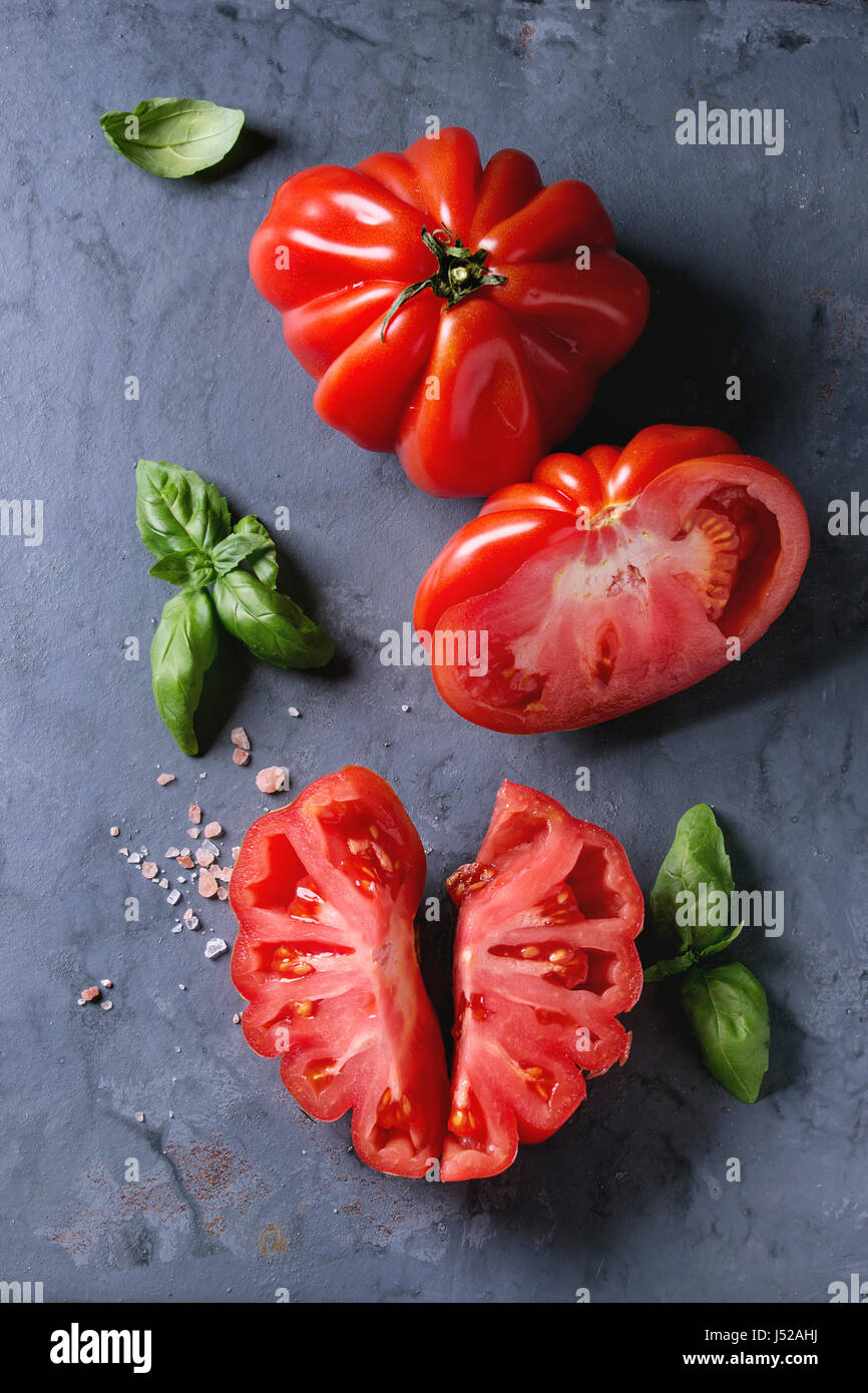 Whole and sliced organic tomatoes Coeur De Boeuf. Beefsteak tomato with