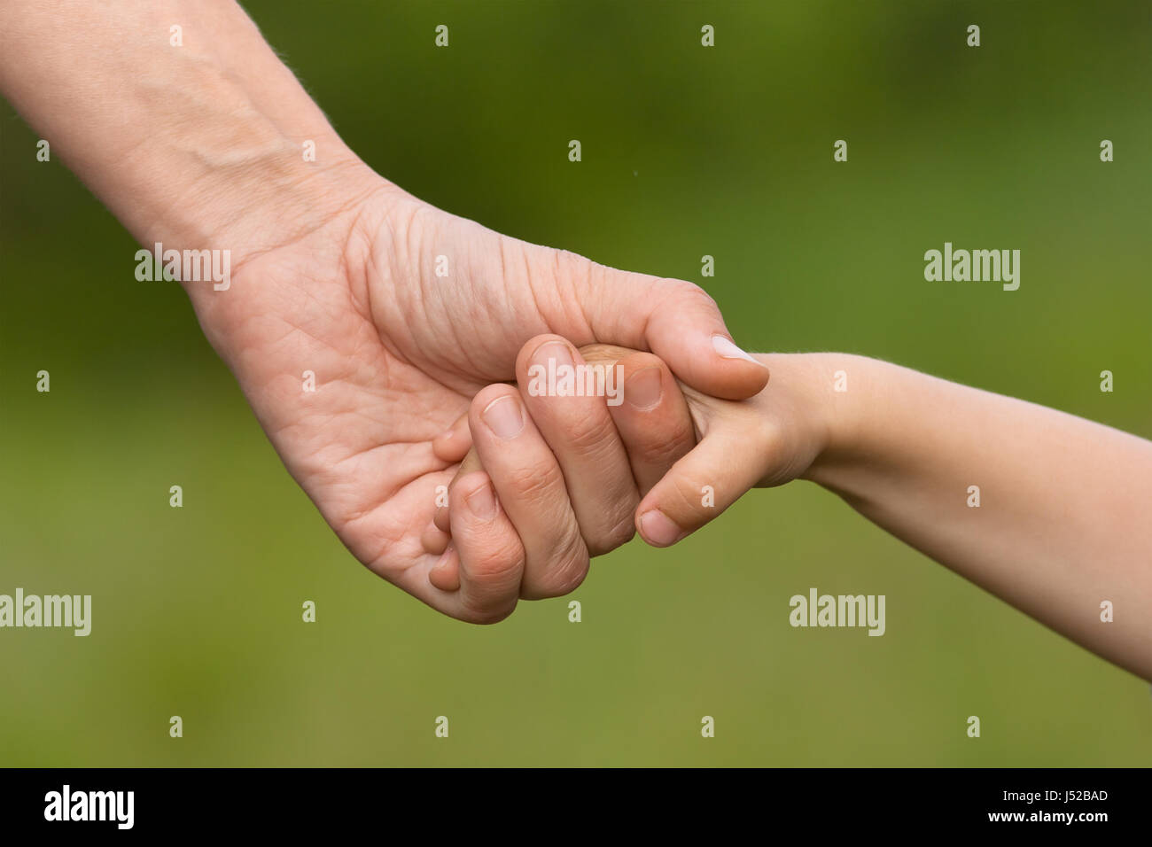 hand of adult holding child on blurred background Stock Photo