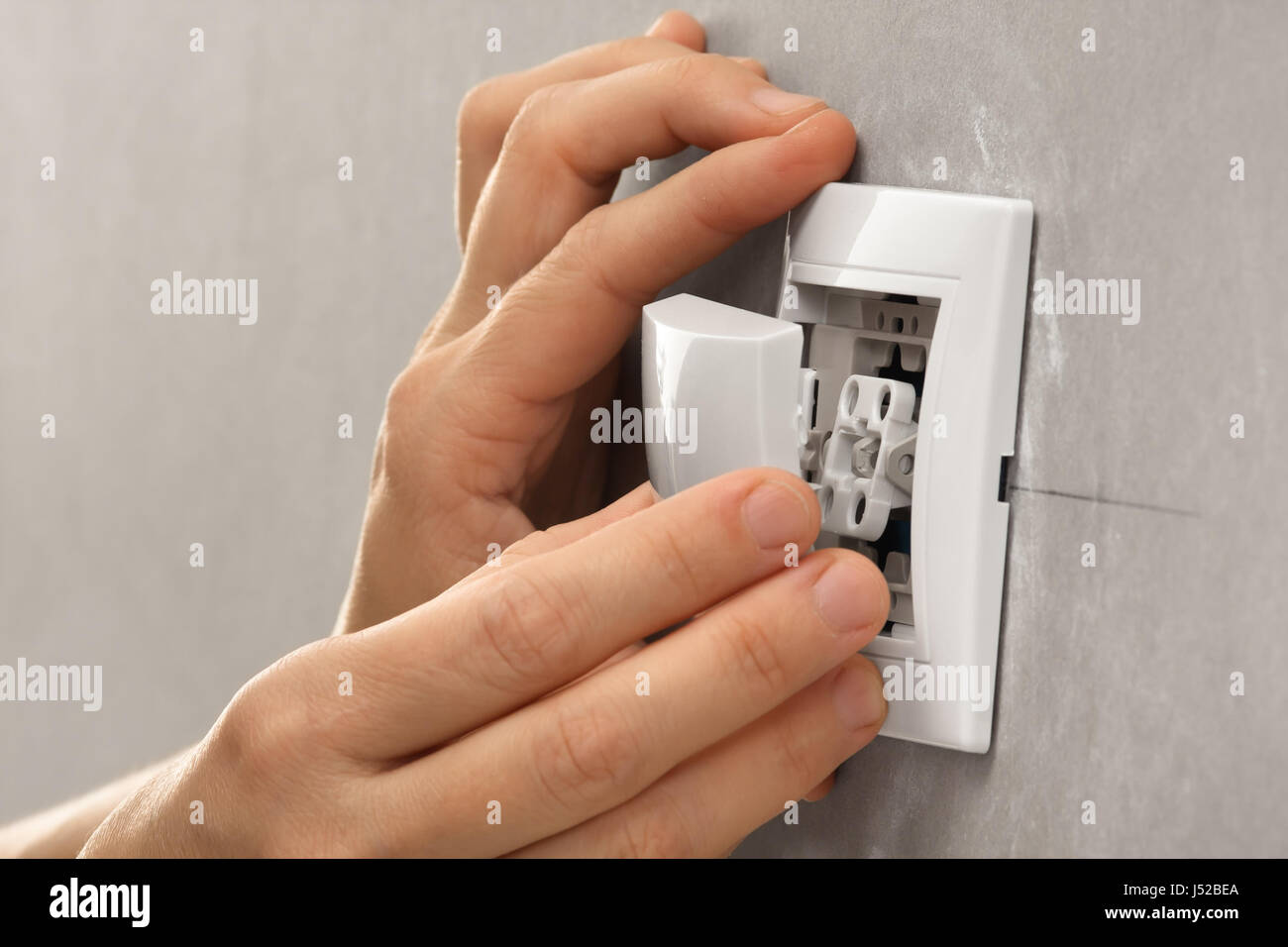 hands of electrician installing light switch on the wall Stock Photo