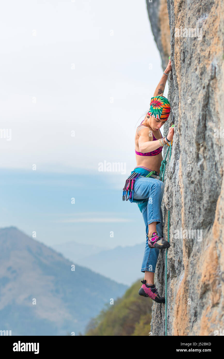 Young woman stairs a wall during a rock course  First rope Stock Photo