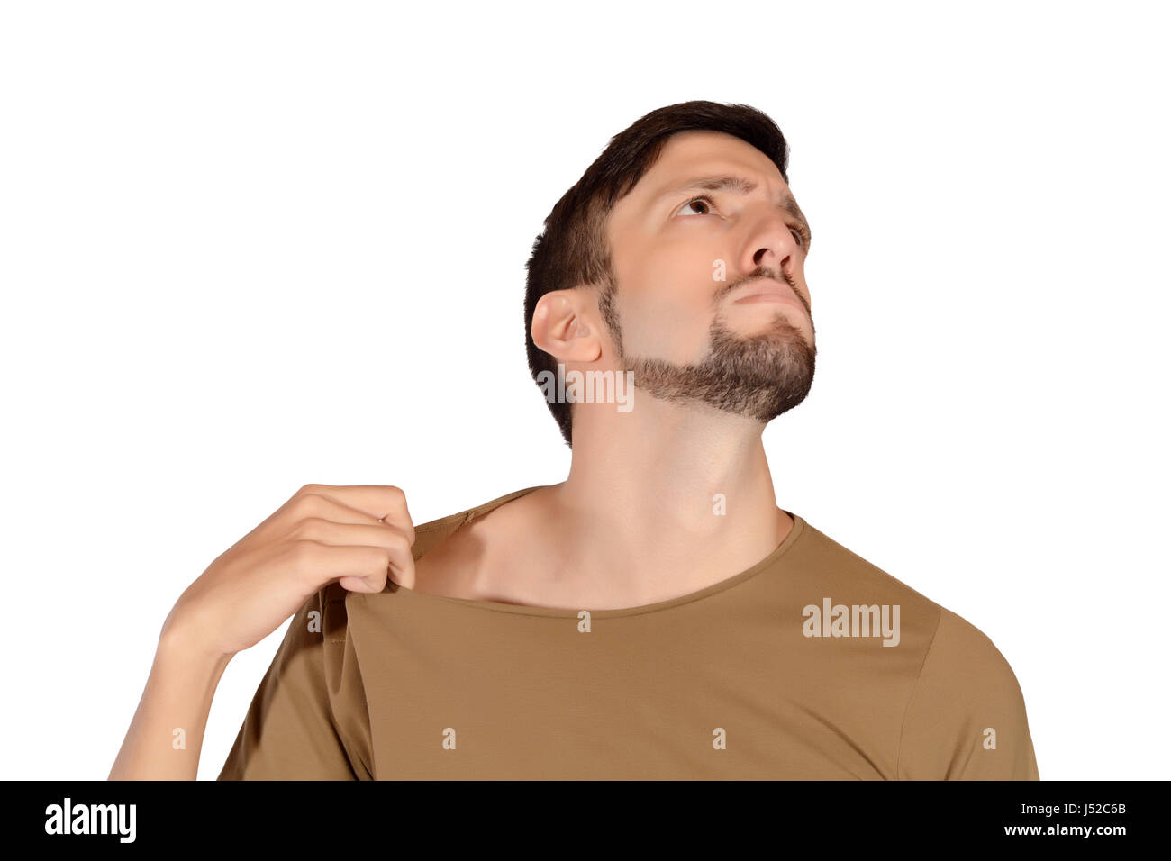 Portrait of young man smelling his armpit. Isolated white background. Stock Photo