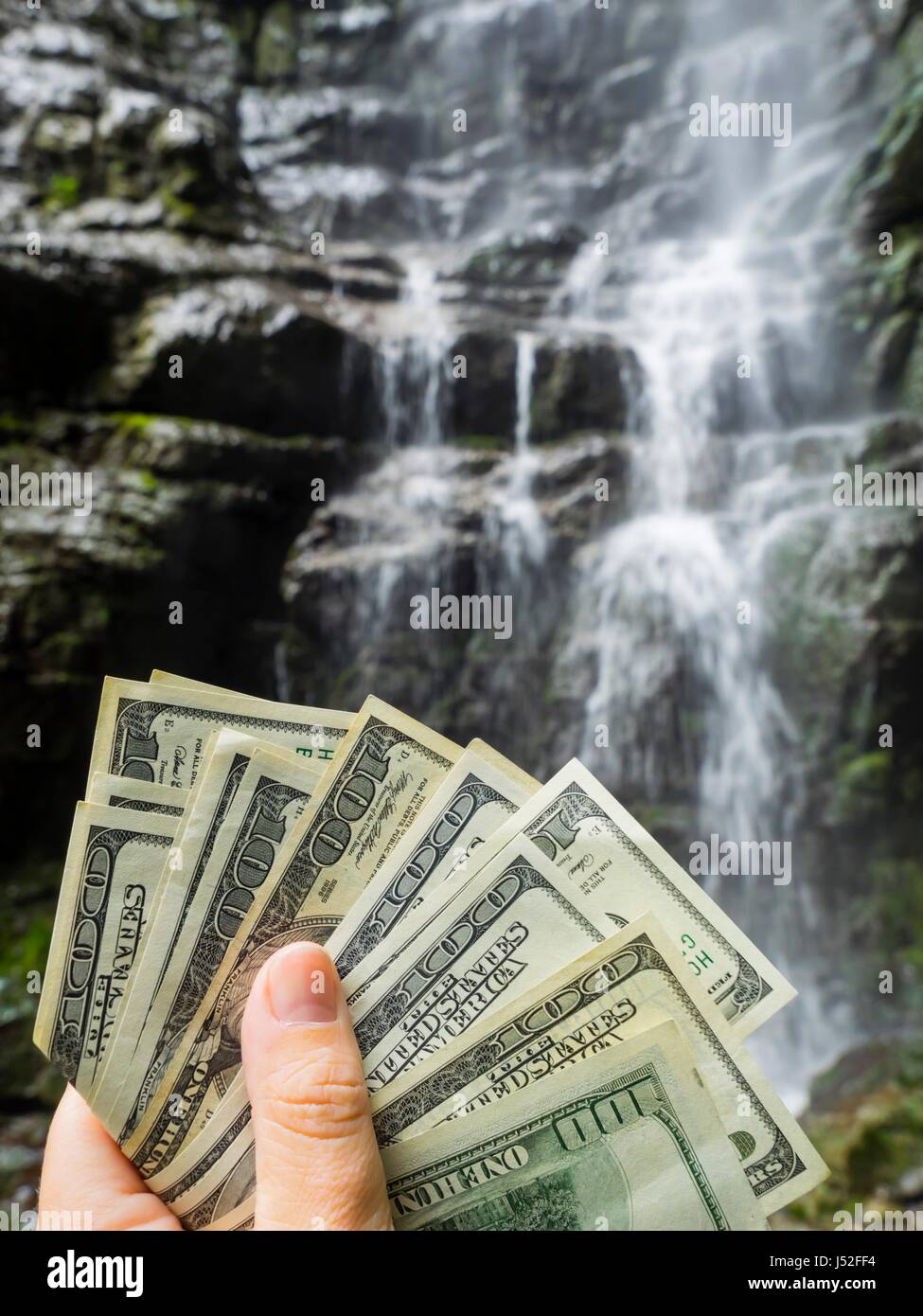 Fresh pour pouring drinking water is expensive money in hand blurry background rocky terrain rocks value valuable price to pay environmental Stock Photo