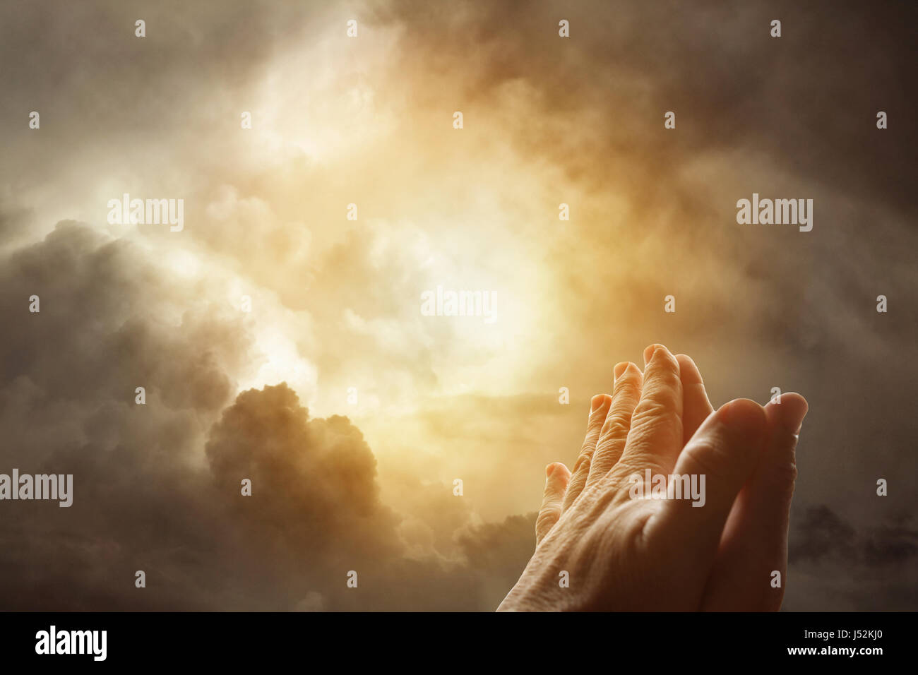 Hands together praying in bright sky Stock Photo - Alamy