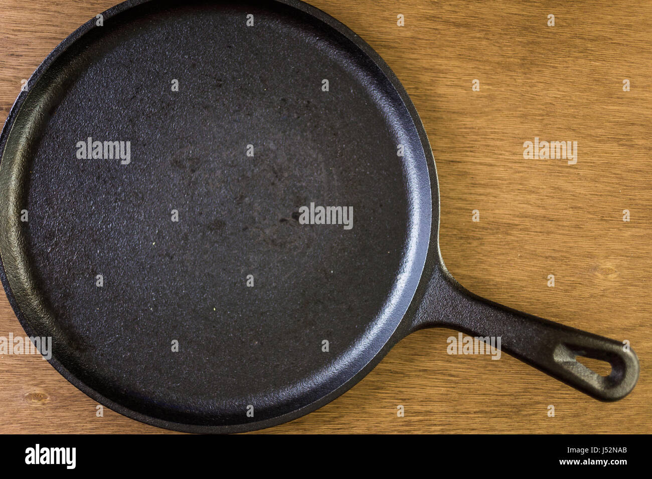 Empty cast iron frying pan on a wood background Stock Photo Alamy