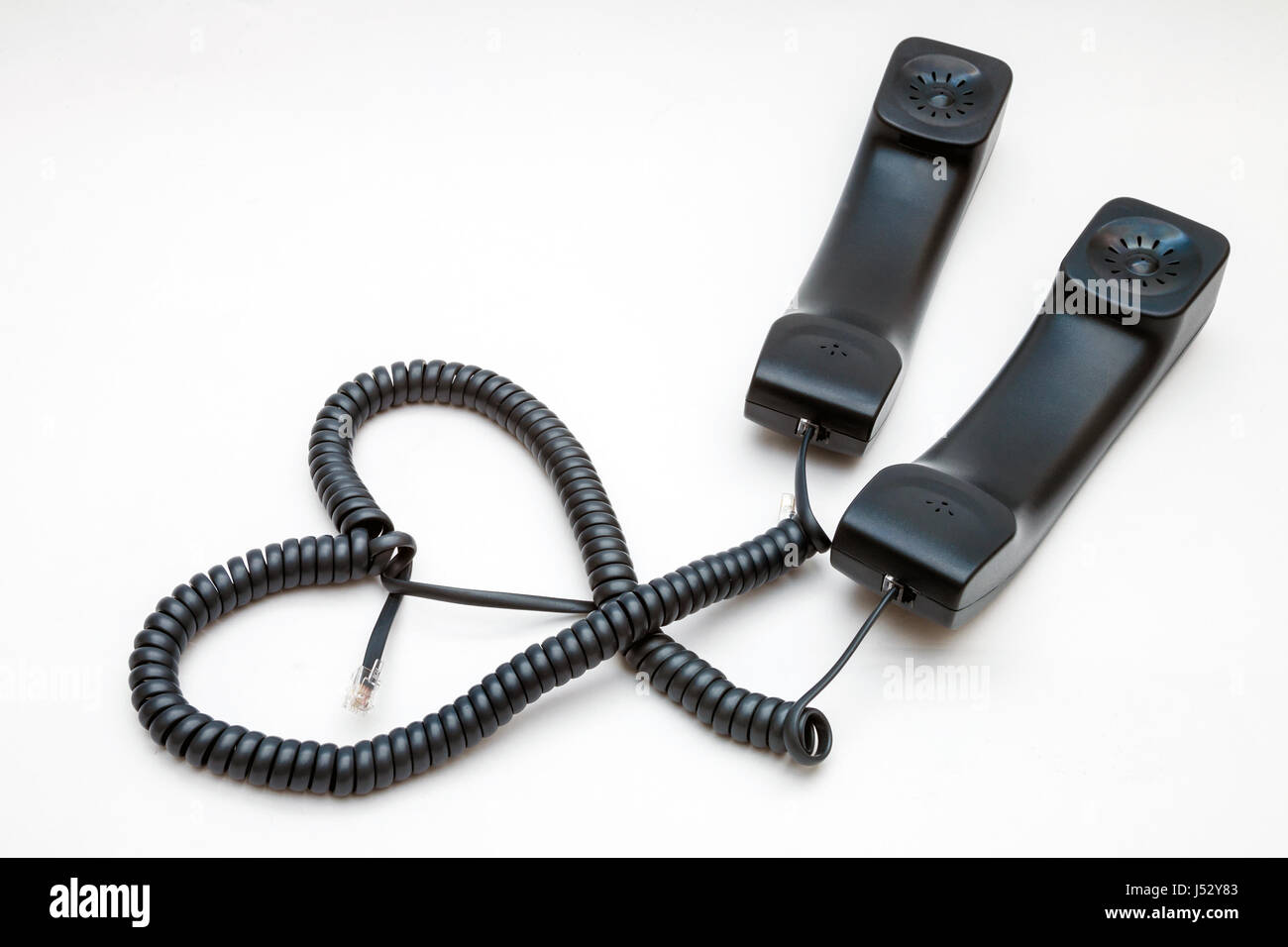 Two handsets with wires in the form of a heart. Love concept Stock Photo