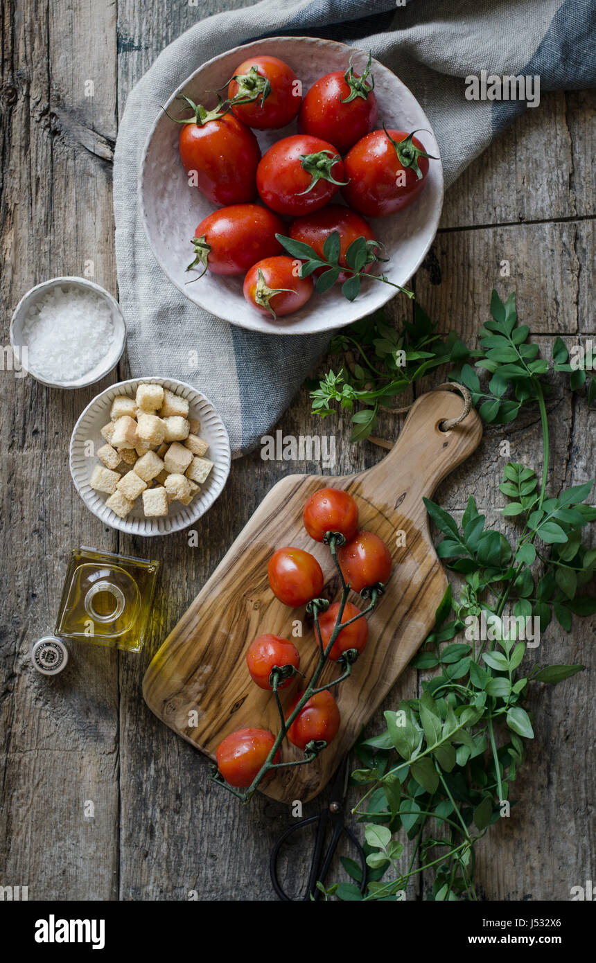 Fresh tomatoes on a vine on a chopping board Stock Photo - Alamy