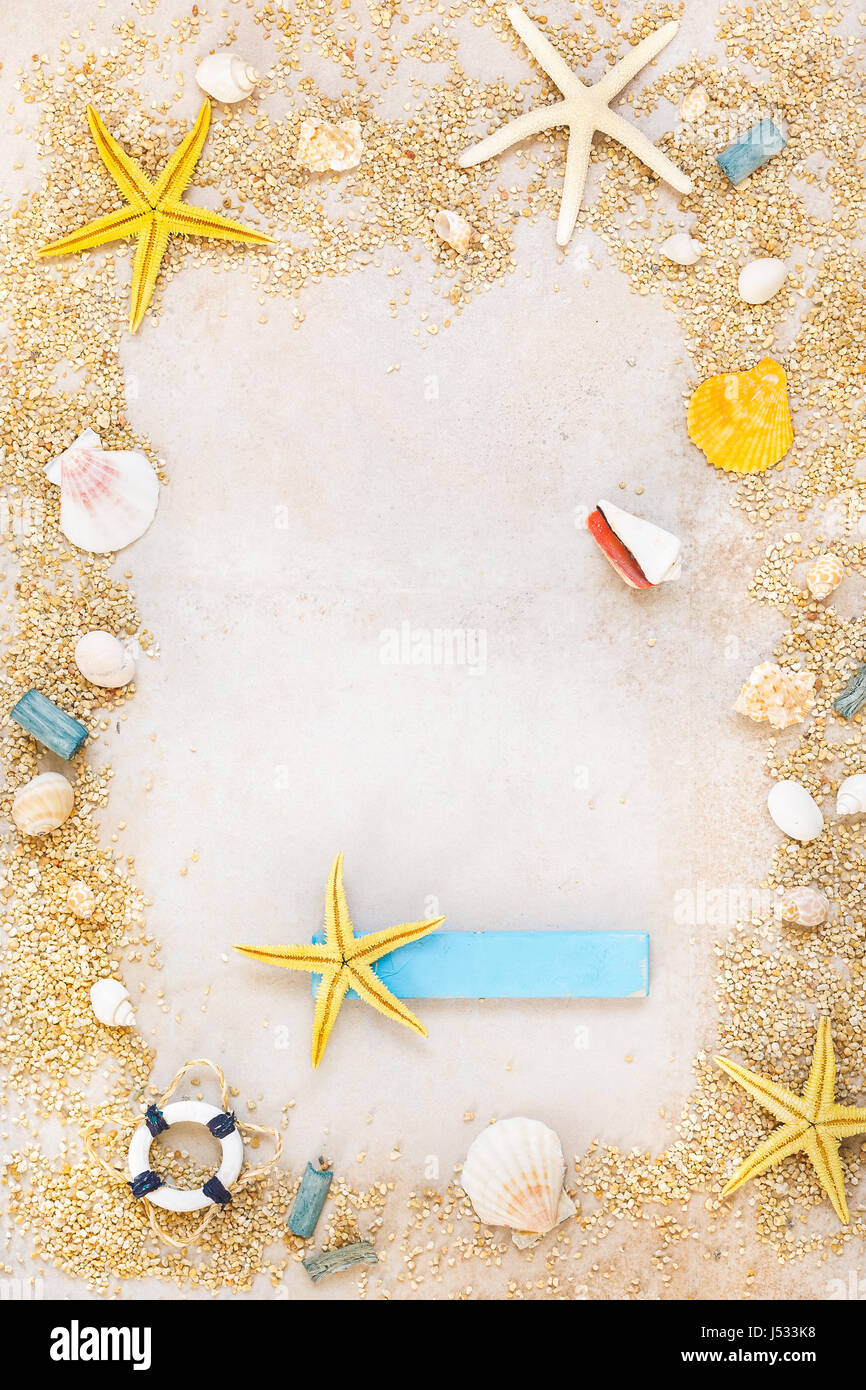 Shells and starfishes on sand background with place for text. Top view ...