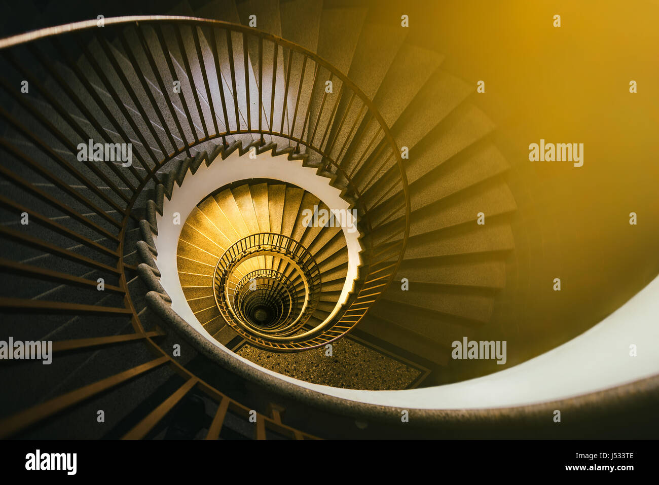 Golden spiral staircase in an old building Stock Photo