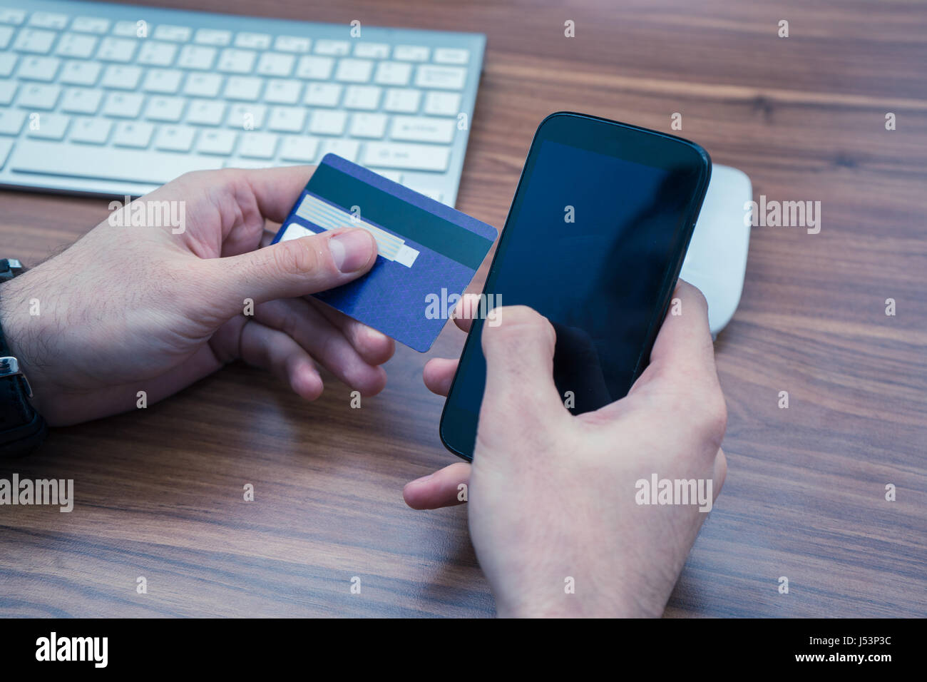 hands holding credit card and a typing on the phone making online purchase Stock Photo