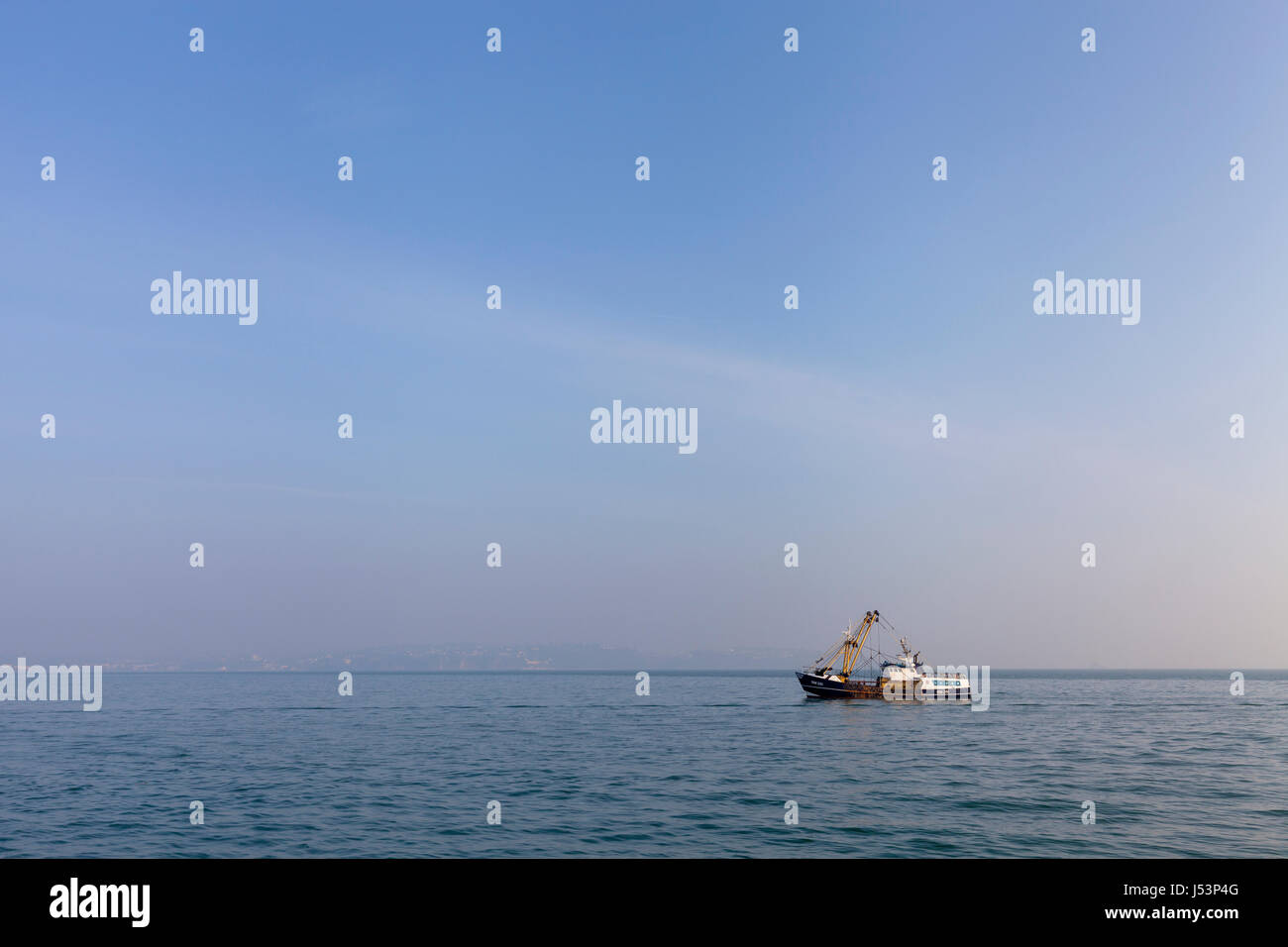 Commercial fishing boat (trawler) returning to Brixham harbour in  Devon, UK on a sunny  morning. Stock Photo