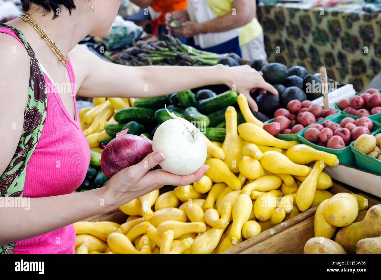 Little Rock Arkansas,River Market,farmers market,buyers,sellers,locally grown produce,woman female women,onion,yellow squash,vegetable,vegetables,farm Stock Photo