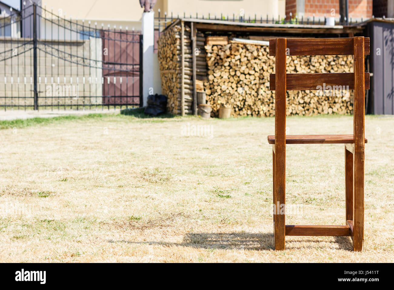 single wooden chair standing on withered grass Stock Photo