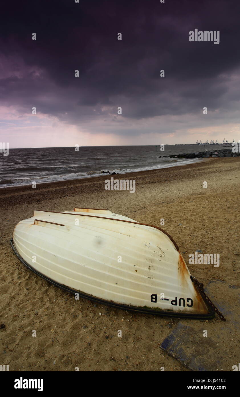 A boat on the beach with dark clouds on Suffolk coast Stock Photo - Alamy