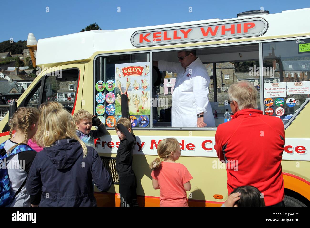 Families choosing ice cream from the Kelly Whip Ice Cream van man Stock Photo