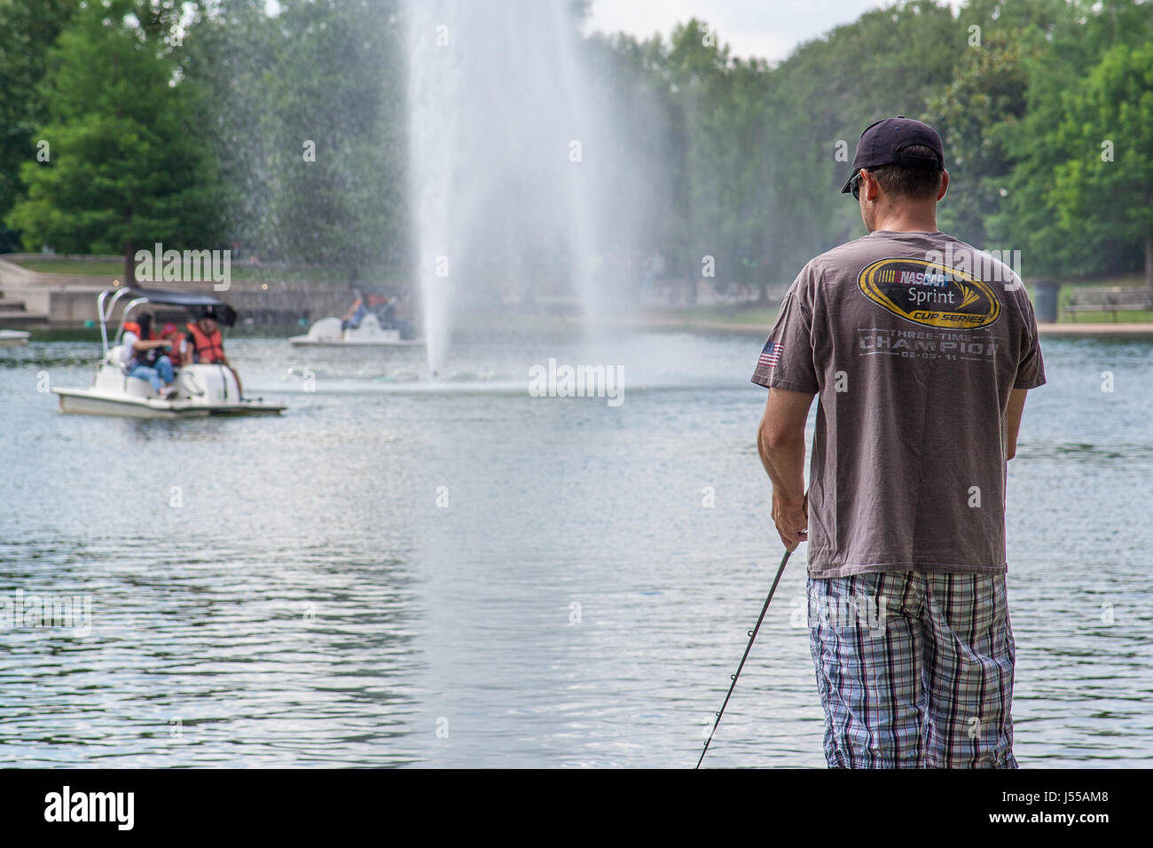 May 2017, Houston, Texas A man fishes in McGovern Lake In Hermann Park