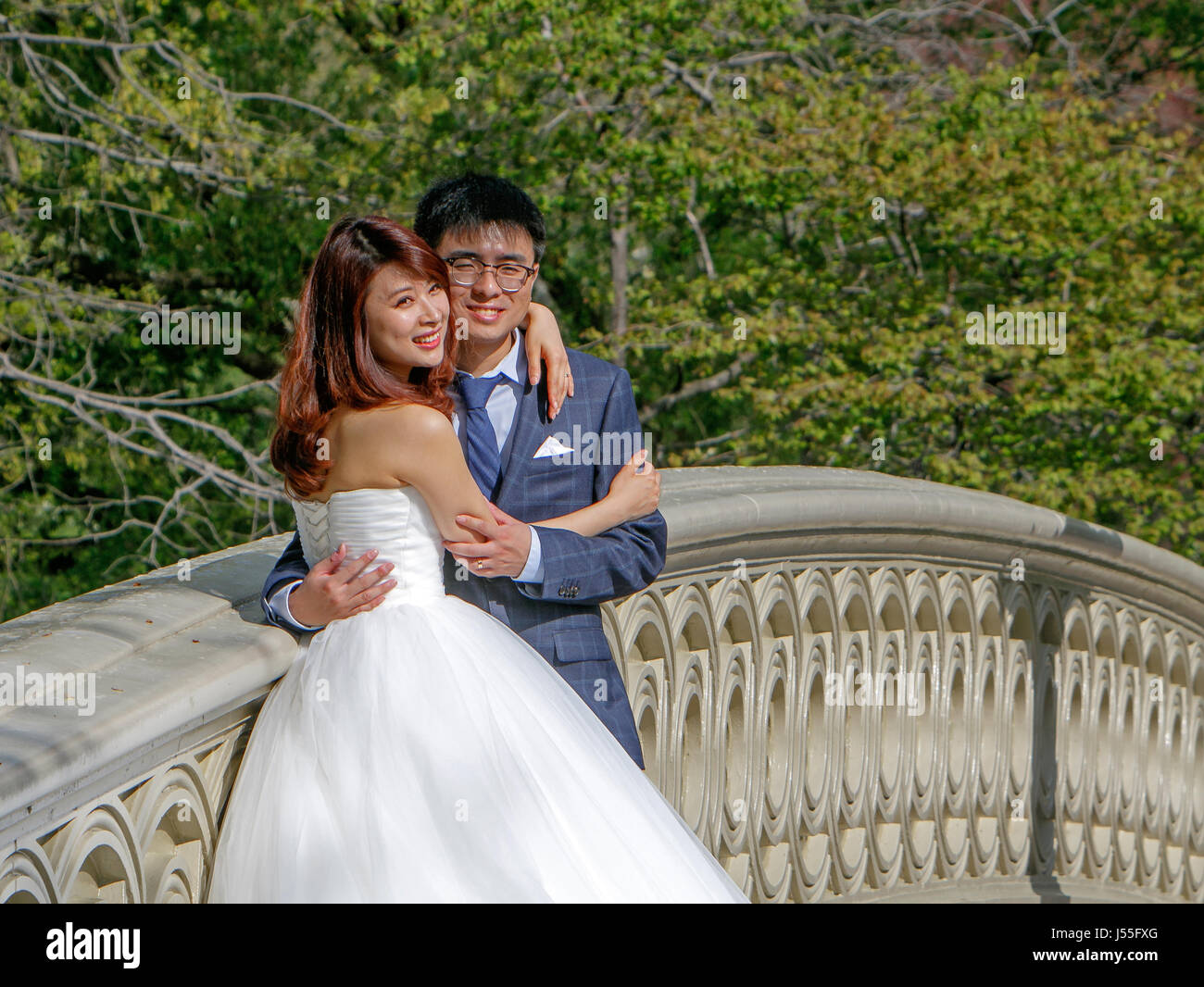 Young Asian couple is posing for a picture during a wedding album photoshoot in Central Park. Stock Photo