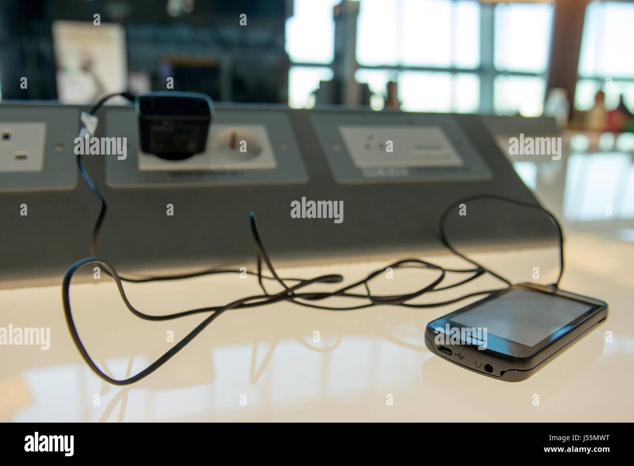 Phone charging on a table at charging station in the lobby. Free