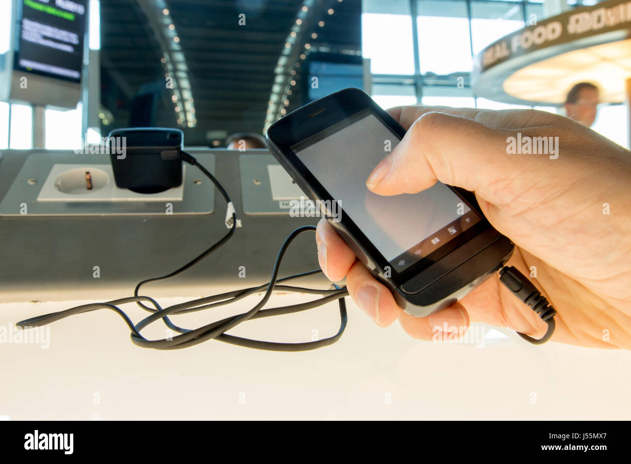 Using a mobile phone while charging the battery at the airport. Phone