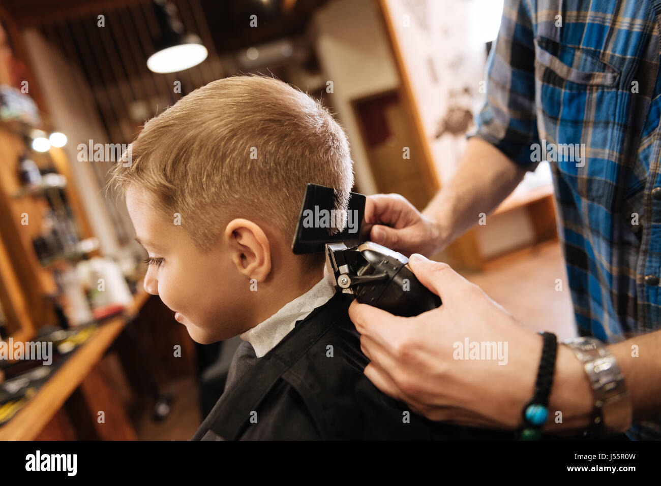 Pleasant professional barber using haircutting machine Stock Photo Alamy