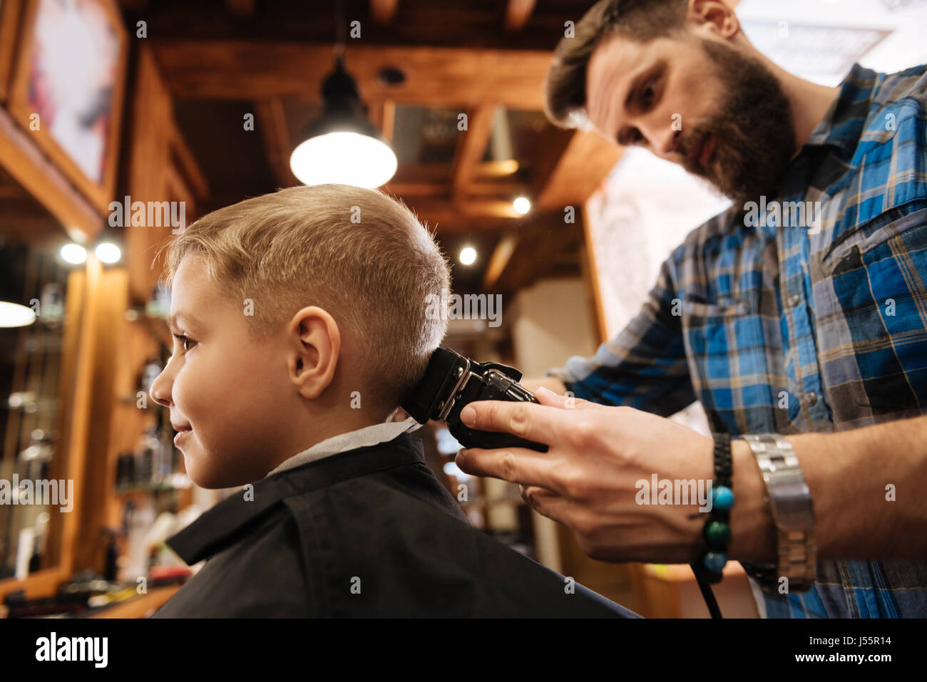 Nice bearded barber doing the haircut Stock Photo
