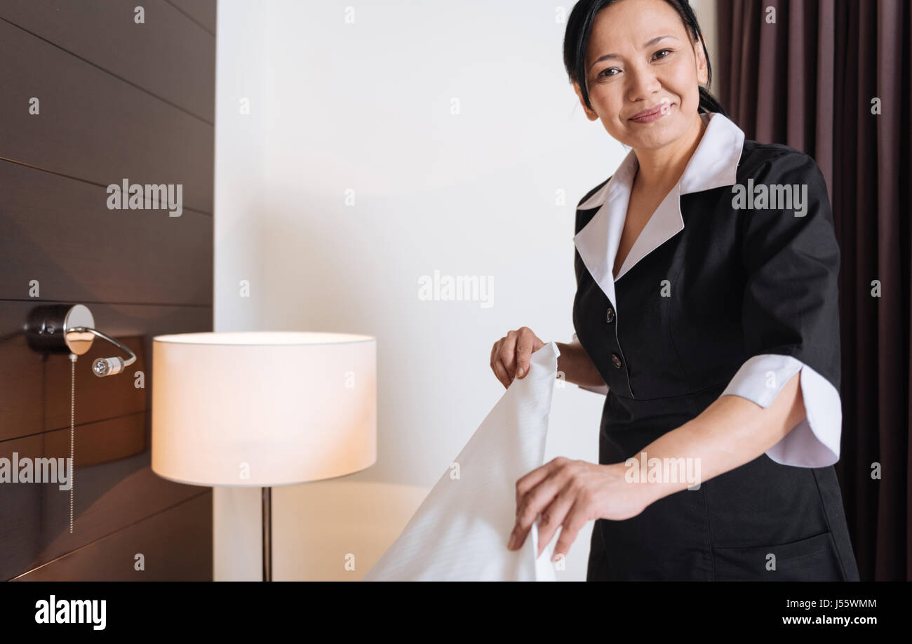 Happy delighted woman working as a hotel maid Stock Photo