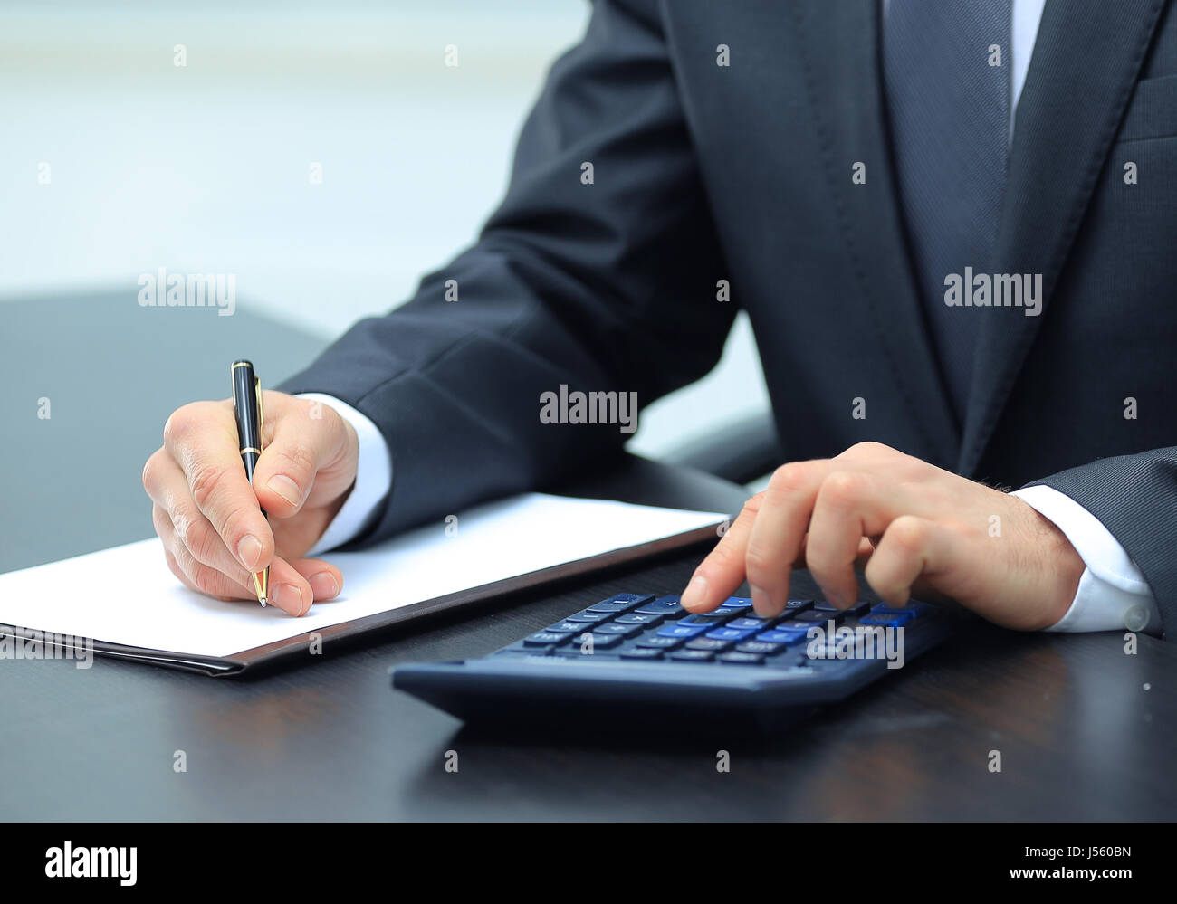 Manager Using Calculator businessman uses a calculator for calculations Stock Photo - Alamy